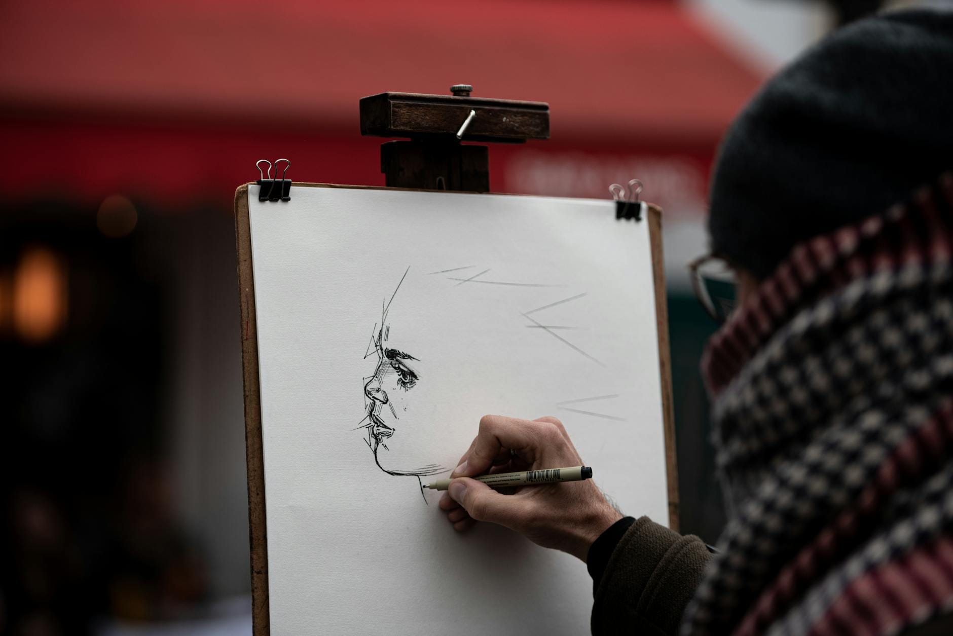 Artysta szkicuje portret przechodnia na ulicy w Paryżu
