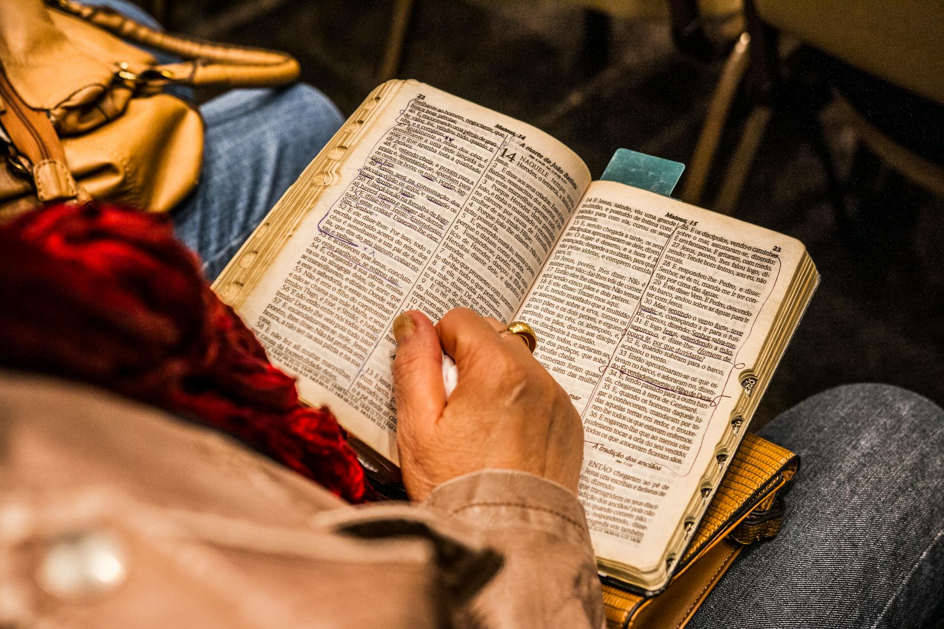 Osoba czytająca Biblię w domu podczas osobistej modlitwy