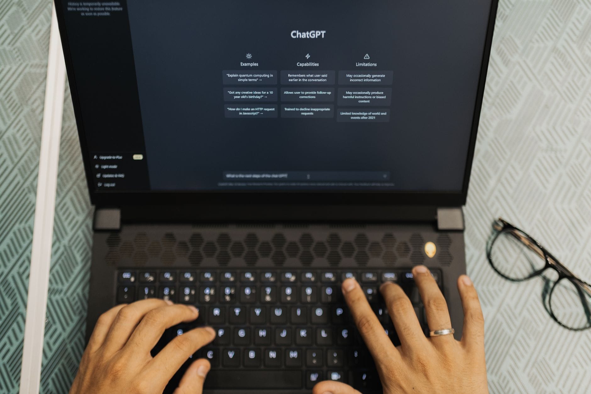 Dłonie piszące na laptopie z otwartym ChatGPT, automatyzacja pracy