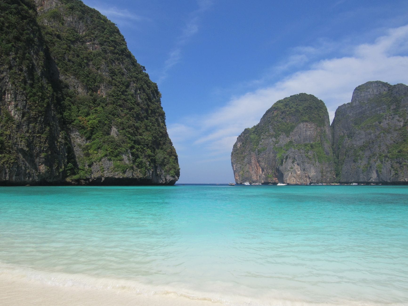 Spokojna plaża na Samui z turkusowym morzem i zielonymi klifami
