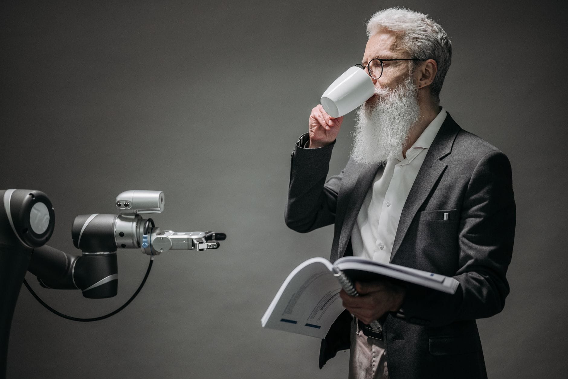 Starszy mężczyzna z książką rozmawia z humanoidalnym robotem